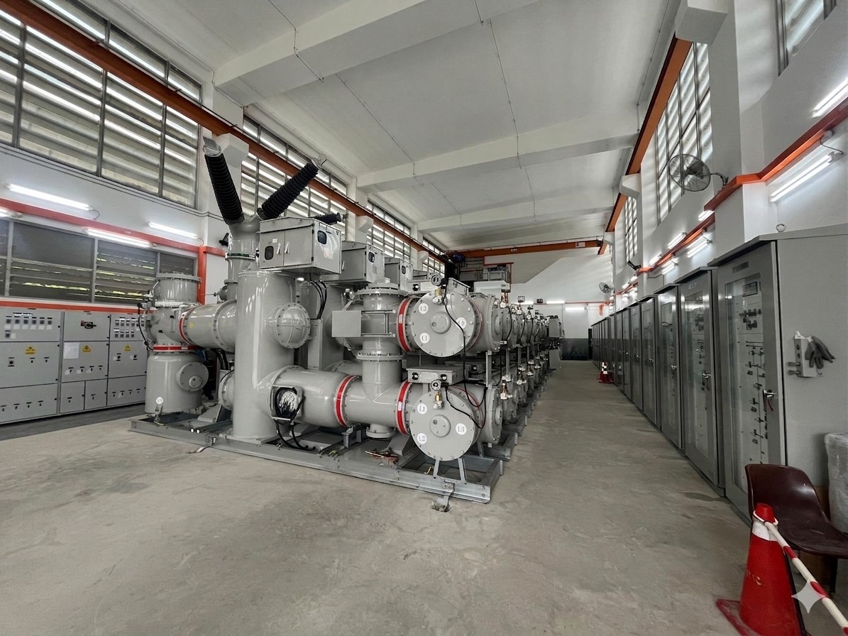 Row of 66kV Gas Insulated Switchgear inside a substation building with control panels.
